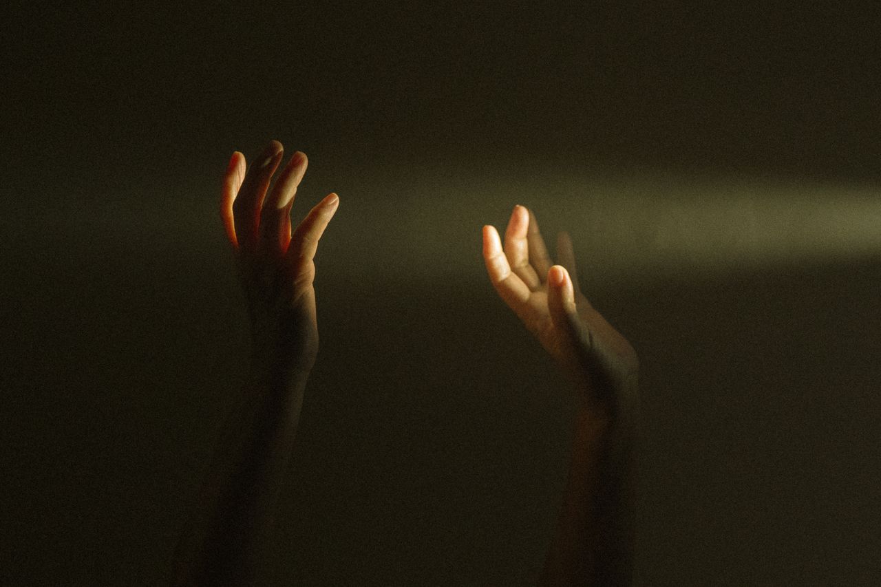 Open hands reaching into a beam of light, a picture of being guided by God